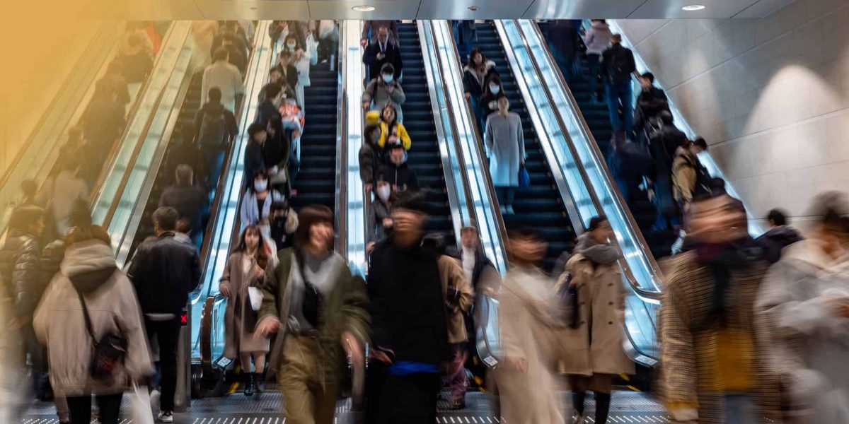 people walking up a busy escalator